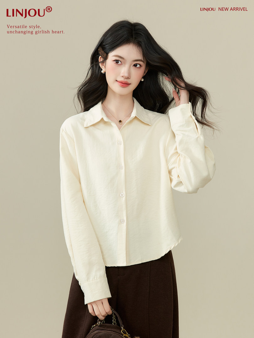 Model wearing a cream button-up long-sleeve blouse