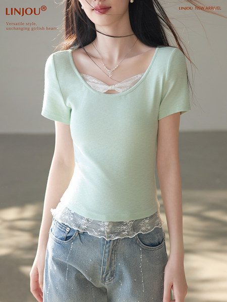 Model wearing a mint green short-sleeve lace-trim top with jeans