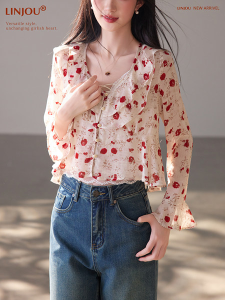 Model wearing a cream floral sheer long-sleeve blouse with jeans