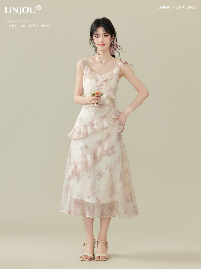 Woman wearing a light pastel ruffled floral midi dress on a neutral background
