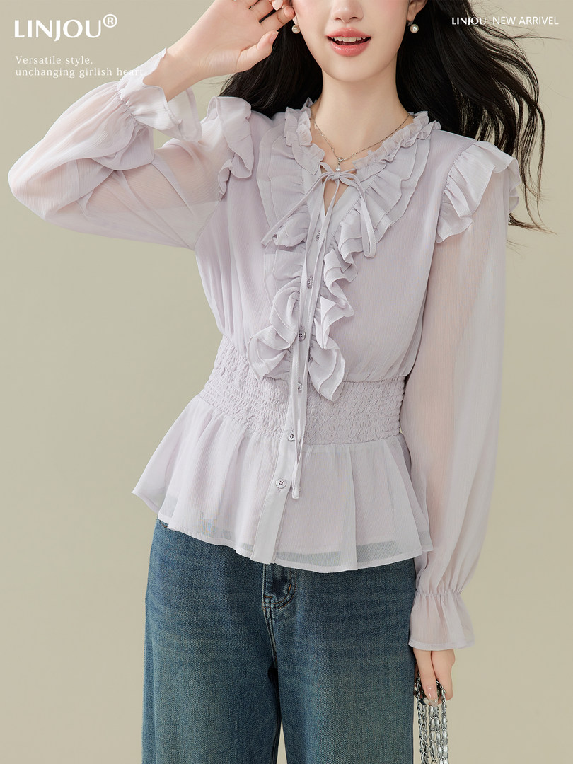 Model wearing a ruffled sheer long-sleeve blouse with buttons and a smocked waist