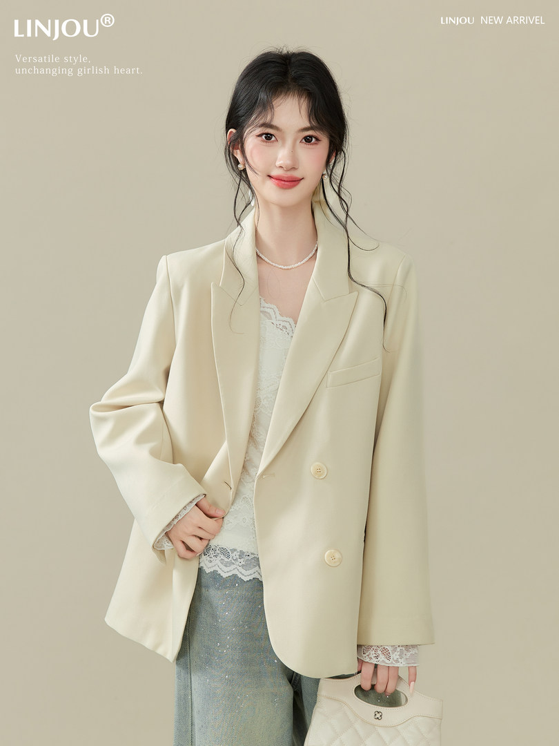 Model wearing a cream oversized blazer with lace top and jeans