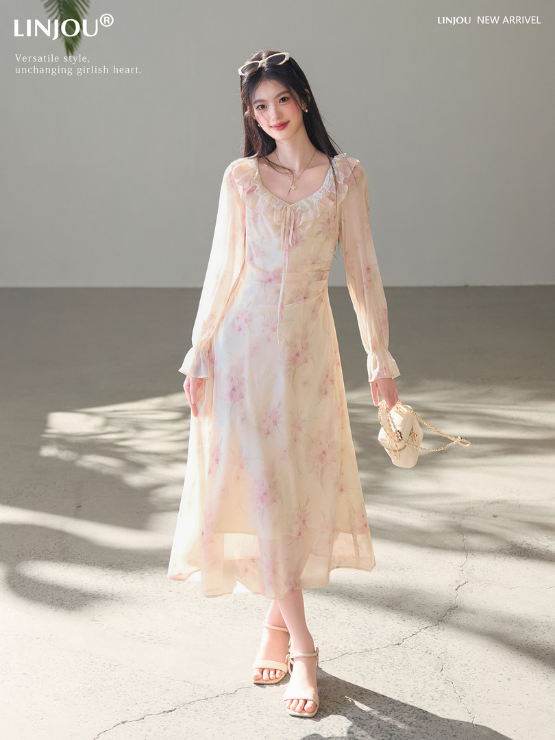 Model wearing a light floral long-sleeve dress with ruffled neckline