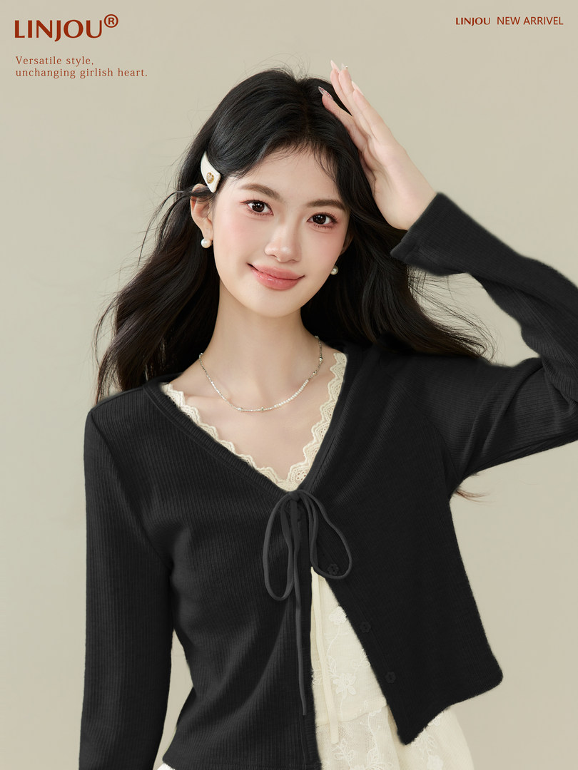 Black ribbed cardigan worn over a lace-trim camisole on a model