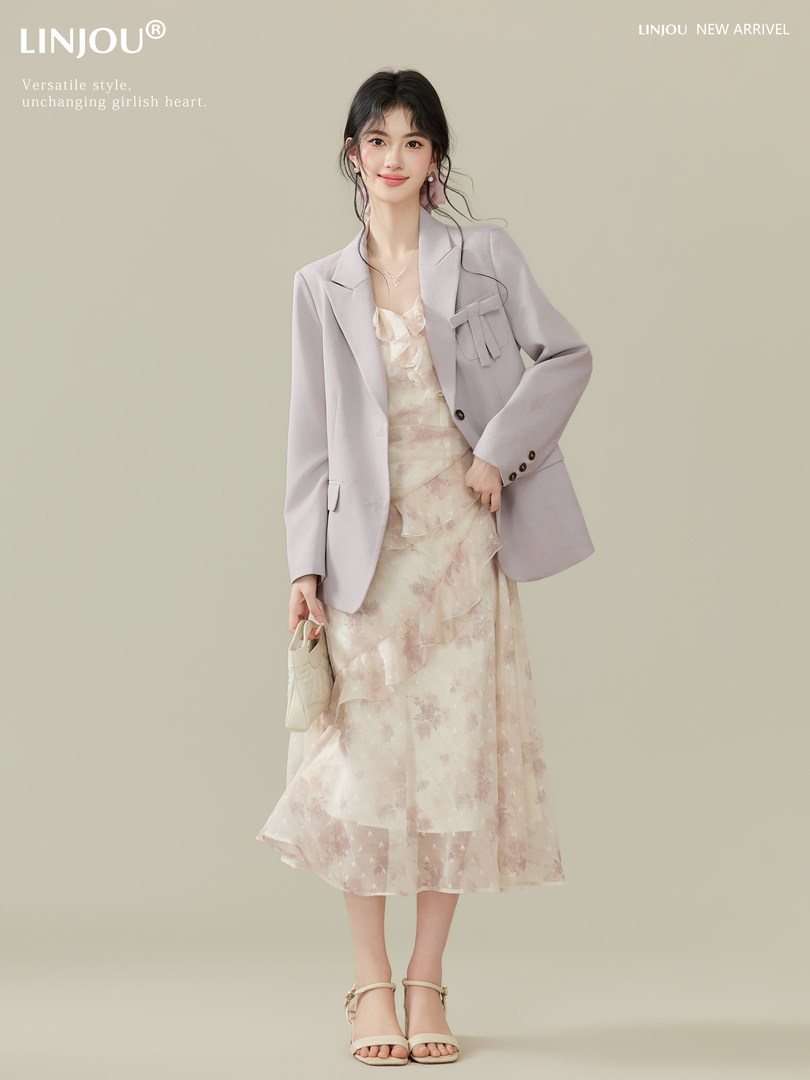 Model wearing a light lavender blazer over a floral midi dress and heels