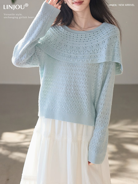 Light blue knit sweater worn by a model over a white skirt