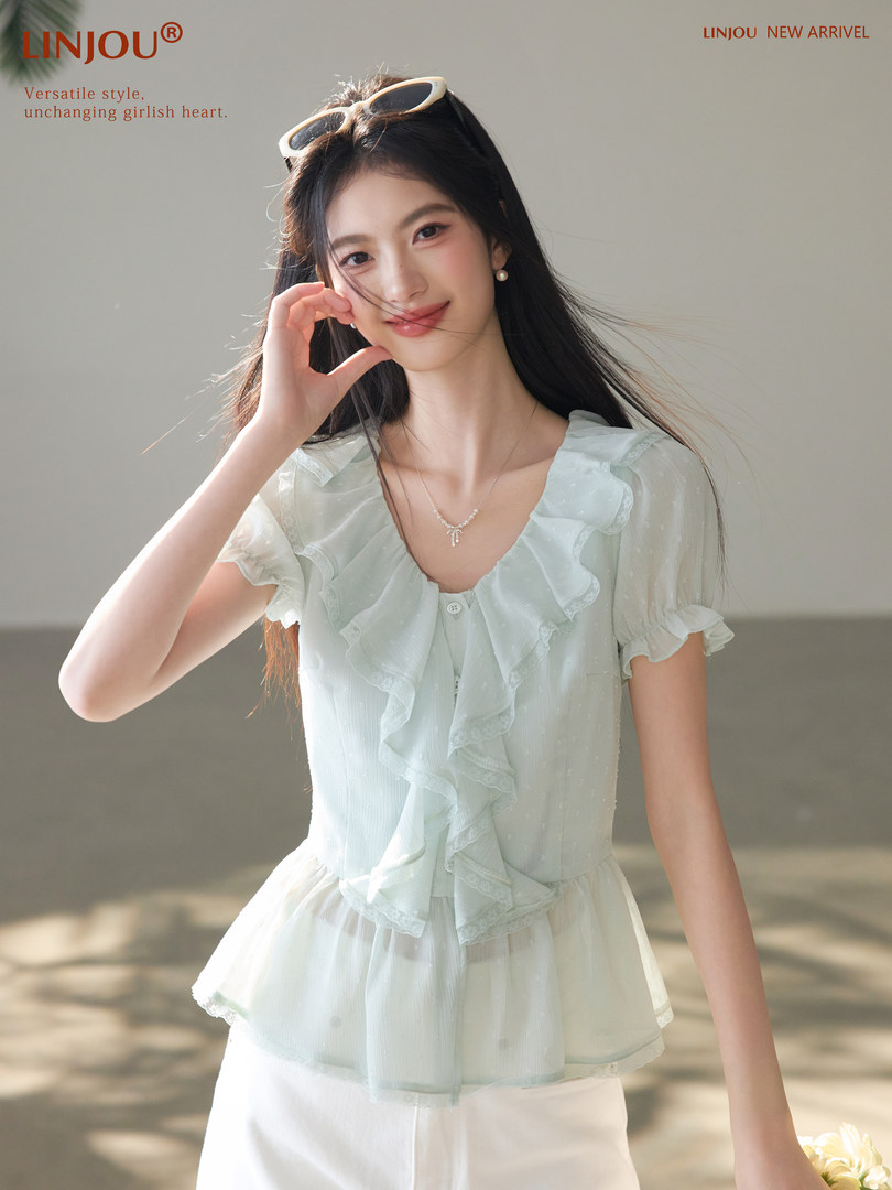 Model wearing a light blue ruffled short-sleeve blouse