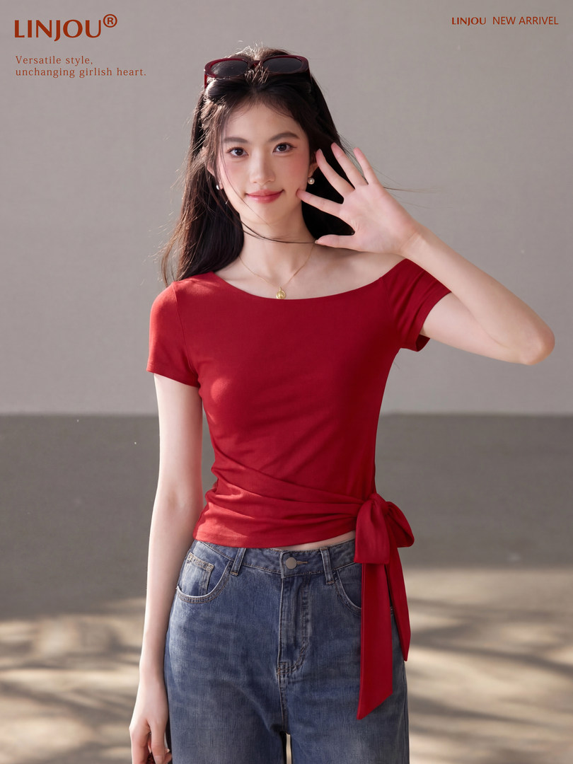 Woman modeling a red off-shoulder tie-waist top with blue jeans