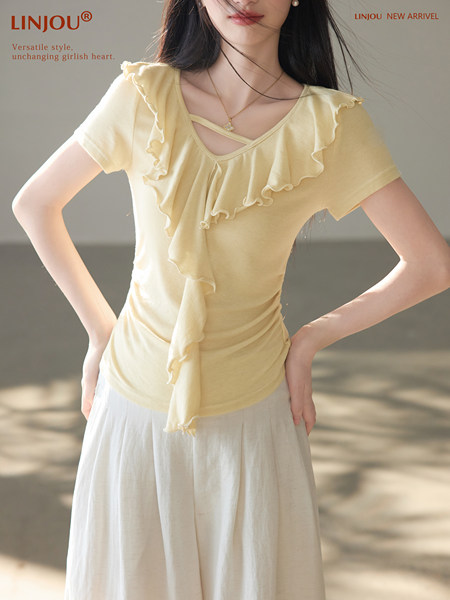 Model wearing a pale yellow ruffled short-sleeve top and light skirt