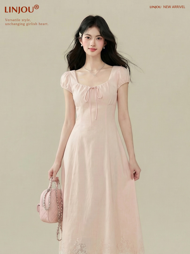 Model wearing a light pink puff-sleeve dress with a small handbag