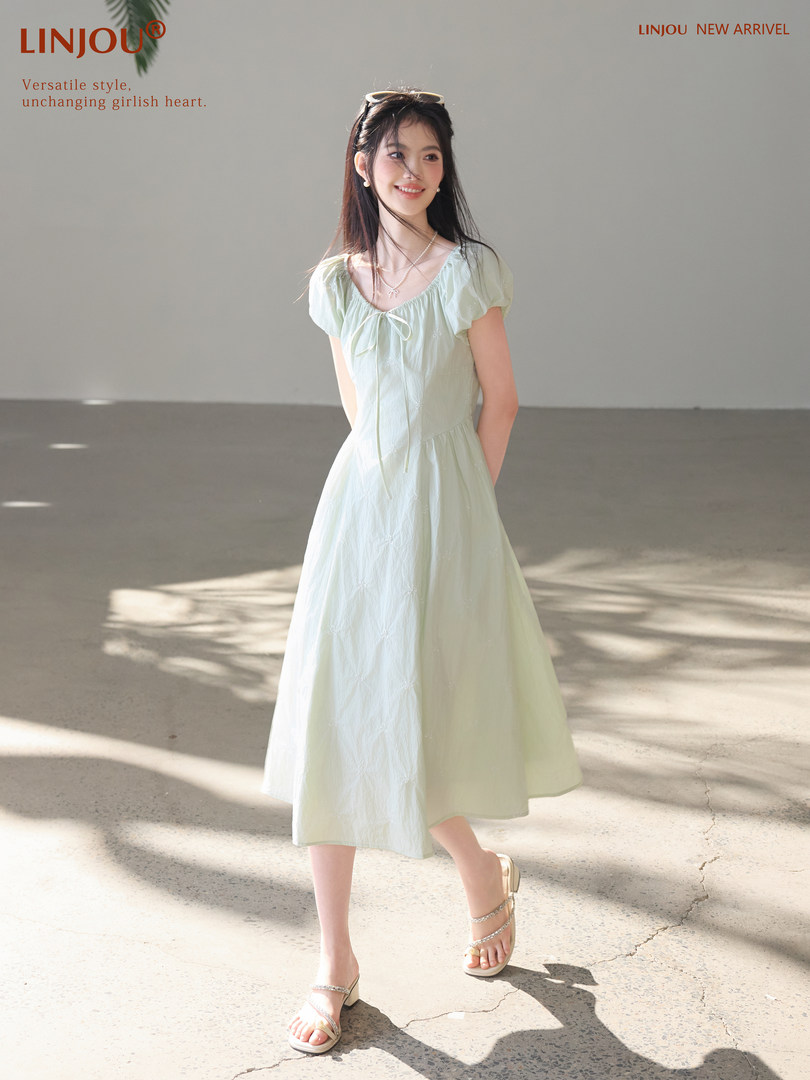 Model wearing a light green puff-sleeve midi dress
