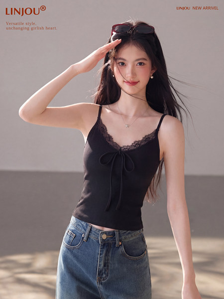 Model wearing a black lace-trim camisole top with blue jeans