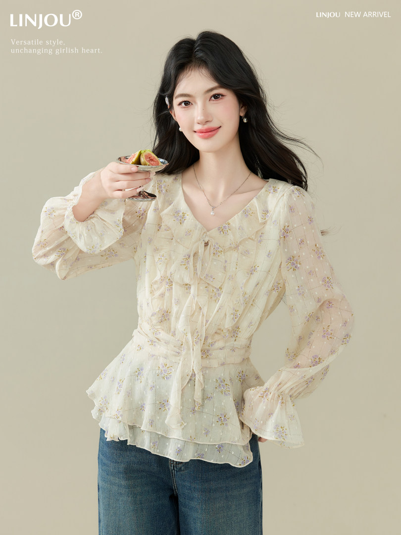 Model wearing a light floral sheer blouse with long sleeves and a tie front