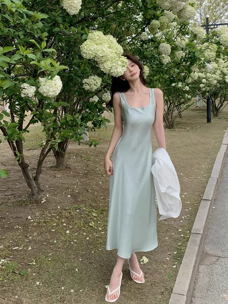 Woman wearing a light blue sleeveless midi dress outdoors