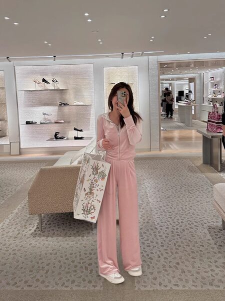 Woman wearing a pink loungewear set with a zip hoodie and wide-leg pants