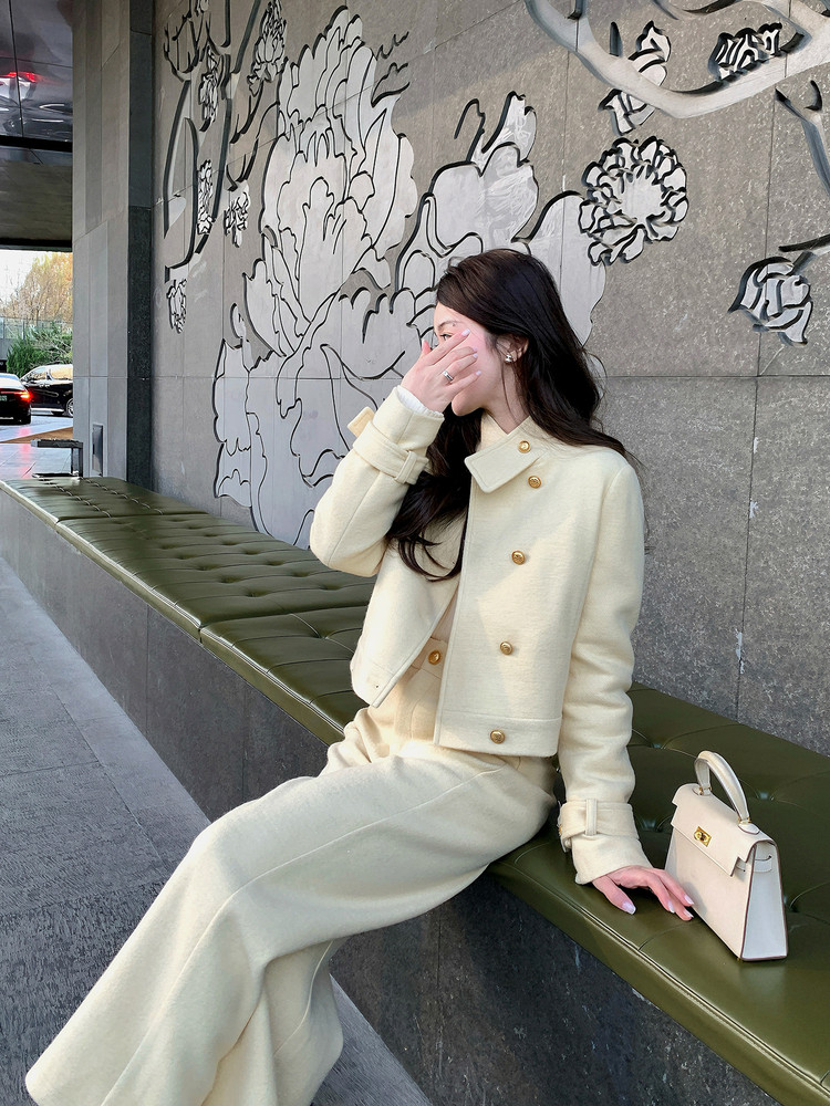 Cream tailored jacket and matching wide-leg pants worn by a model with a small handbag
