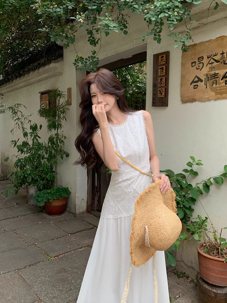White sleeveless lace dress worn by a model outdoors