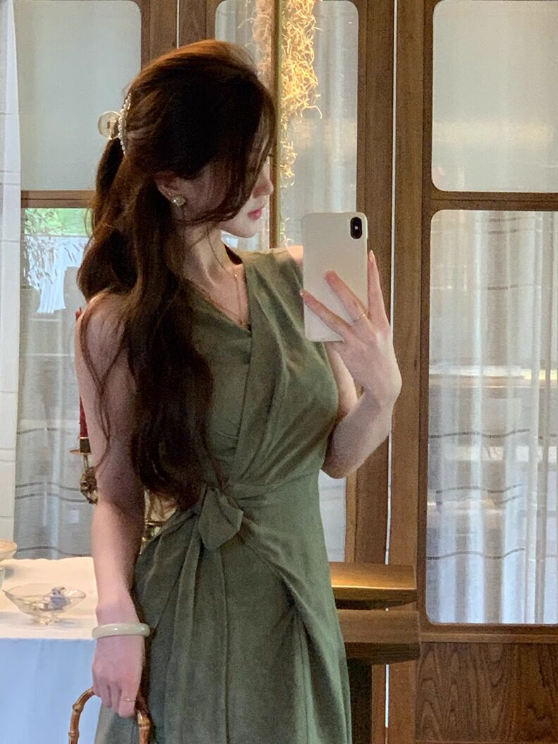 Olive green sleeveless wrap dress worn by a woman