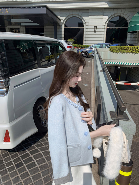 Model wearing a light blue cardigan with blue trim details