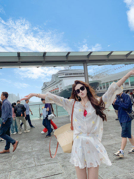 Woman wearing a light floral white dress at a cruise port