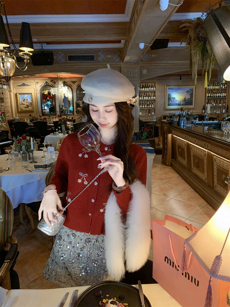 Woman wearing a red embellished cardigan and silver sequin skirt in a restaurant