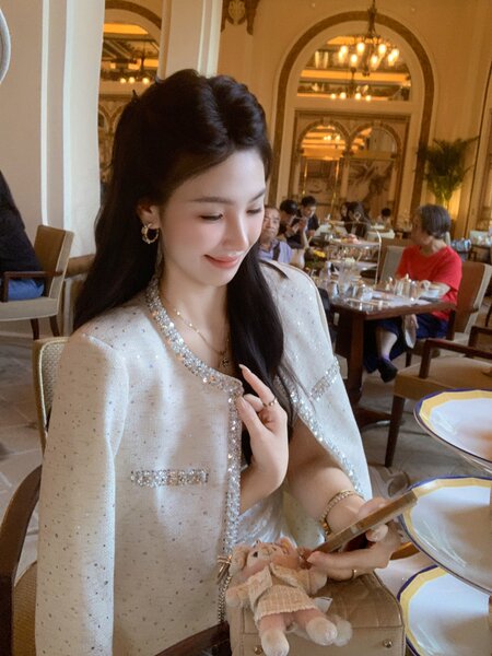 Woman wearing a sparkly white embellished cape jacket at a restaurant