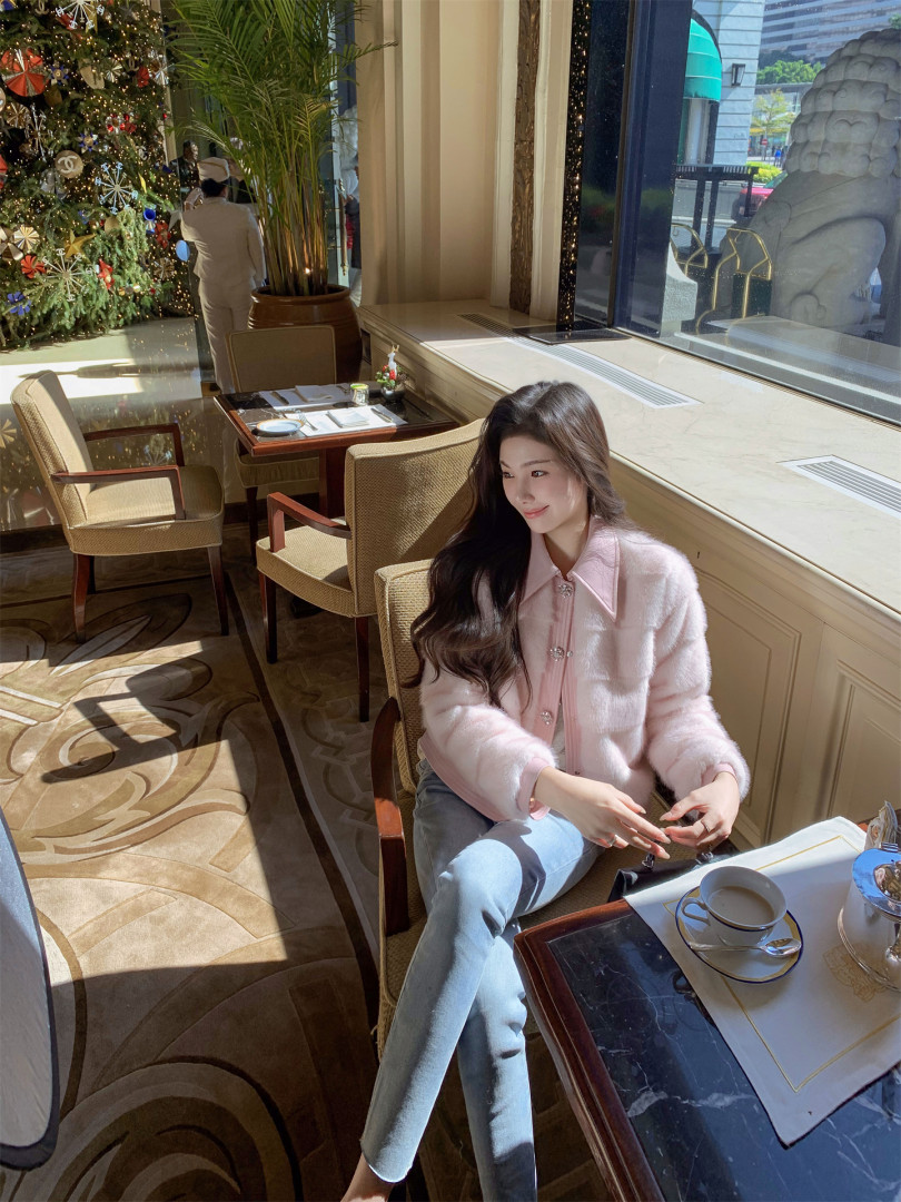 Woman wearing a soft pink fuzzy cardigan in a restaurant setting