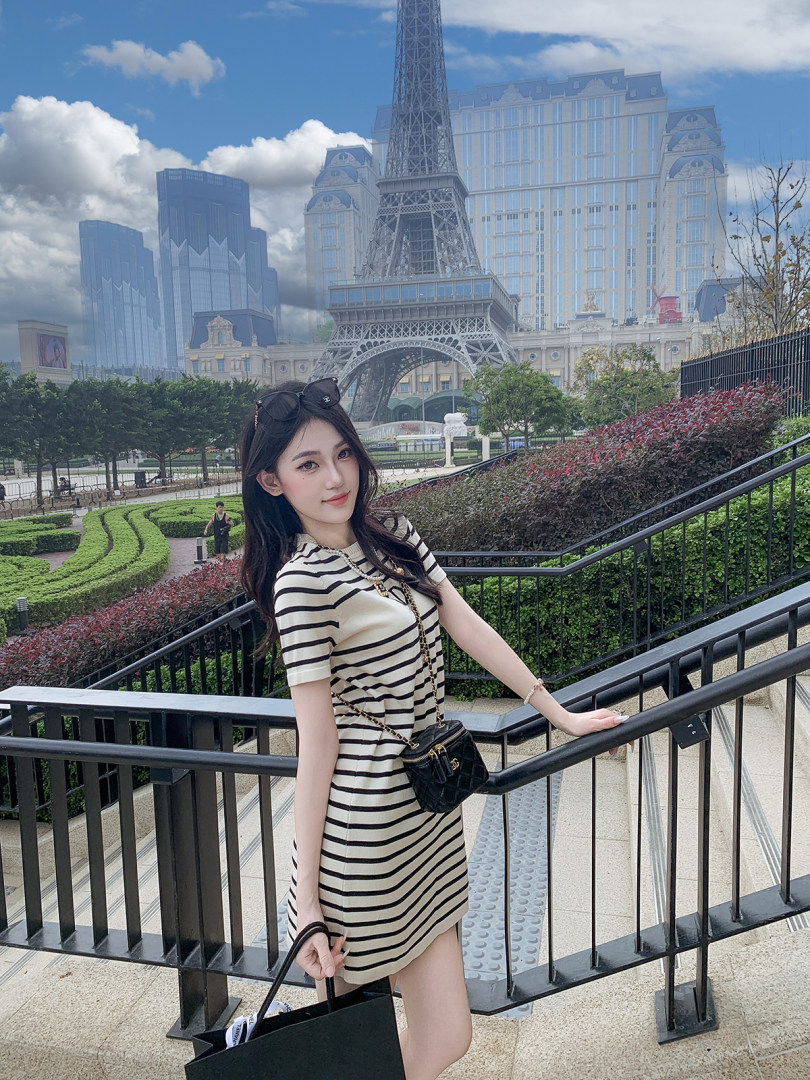 Woman wearing a striped short-sleeve dress outdoors near the Eiffel Tower