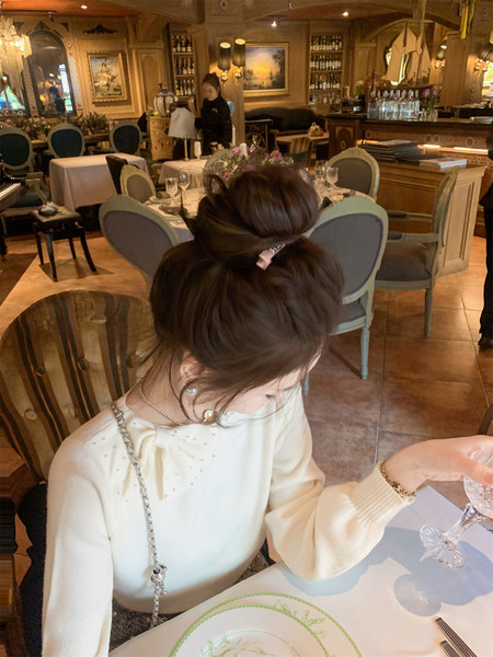 Woman wearing a cream long-sleeve bow-detail top at a restaurant