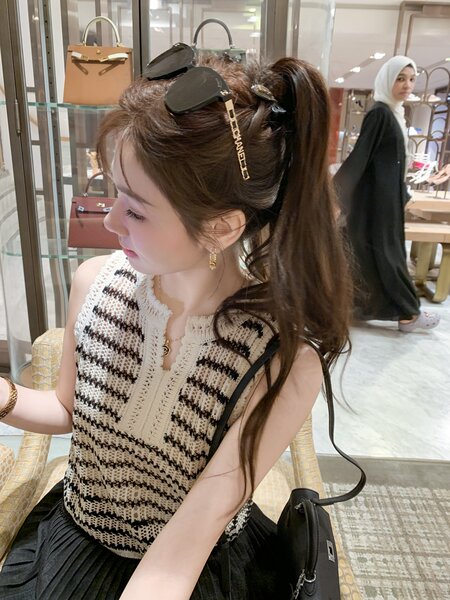 Woman wearing a sleeveless striped knit top in a boutique
