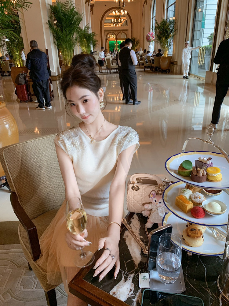 Woman wearing a cream elegant dress in a luxury hotel lounge