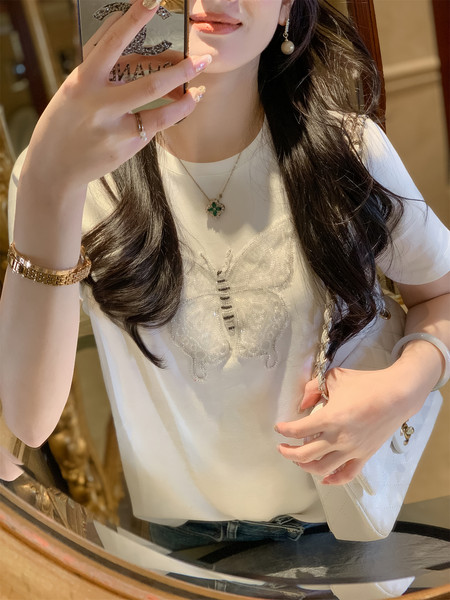 Woman wearing a white embellished short-sleeve T-shirt in a mirror selfie