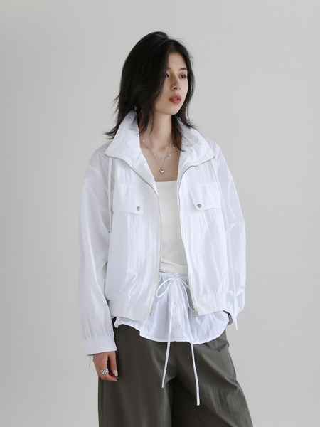 Model wearing a white lightweight zip-up jacket with matching casual pants