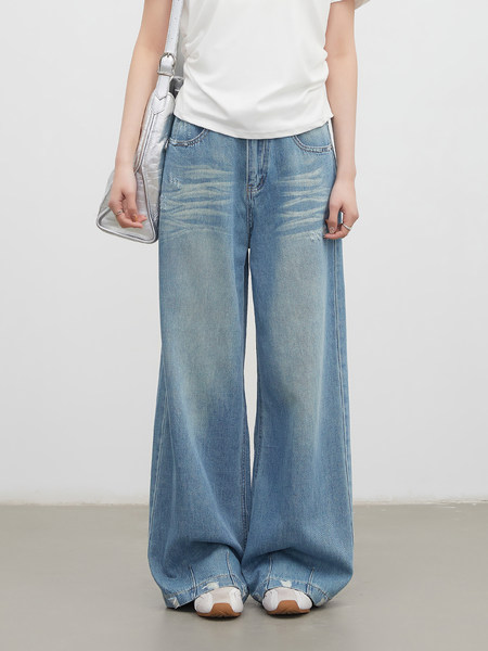 Model wearing light blue wide-leg jeans with a white top and silver shoulder bag