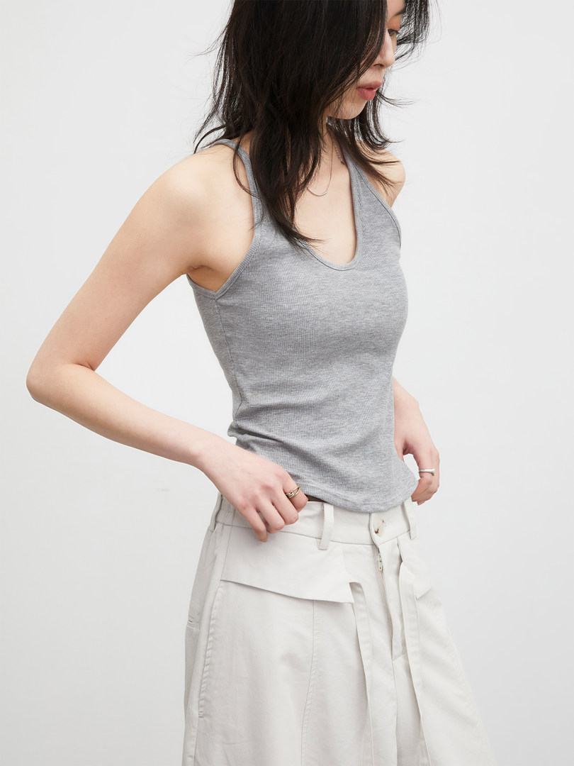 Model wearing a gray ribbed tank top with white pants