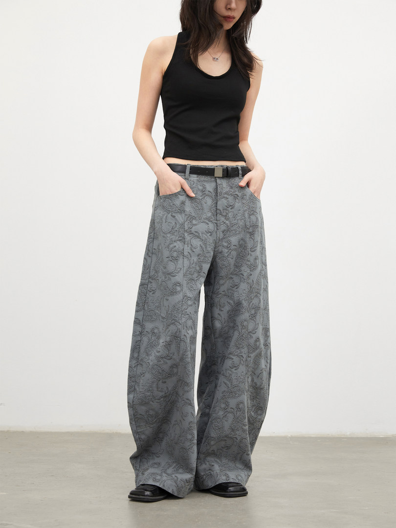 Model wearing gray patterned wide-leg trousers with a black tank top