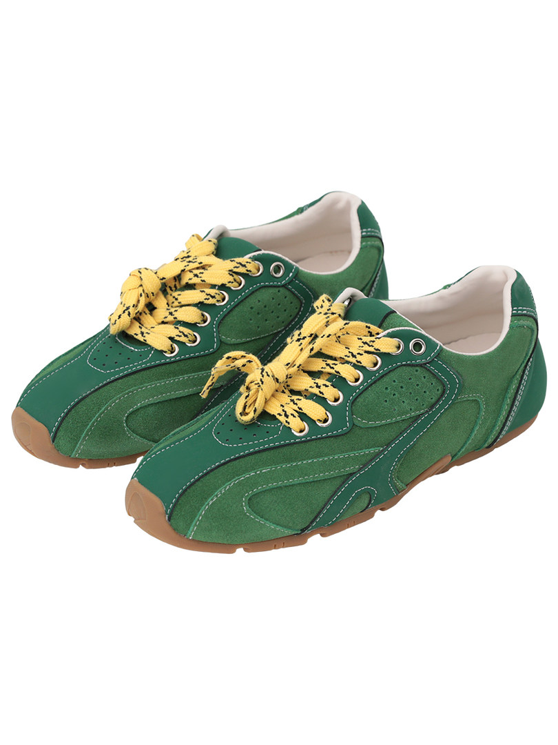 Green low-top sneakers with yellow laces on a white background
