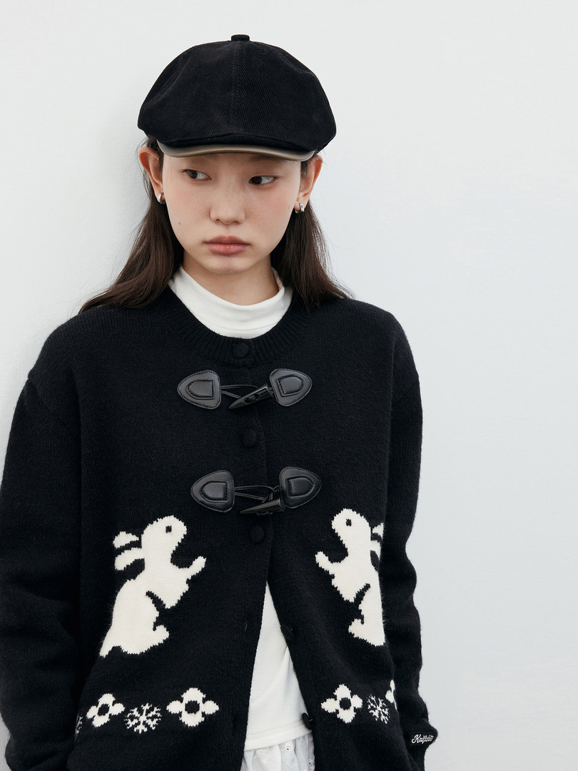 Black knit cardigan with white graphic patterns worn by a model