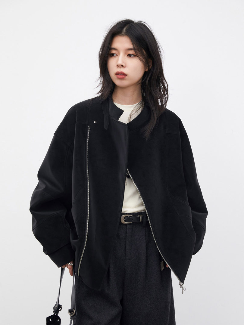 Model wearing a black zip-up jacket over a white top