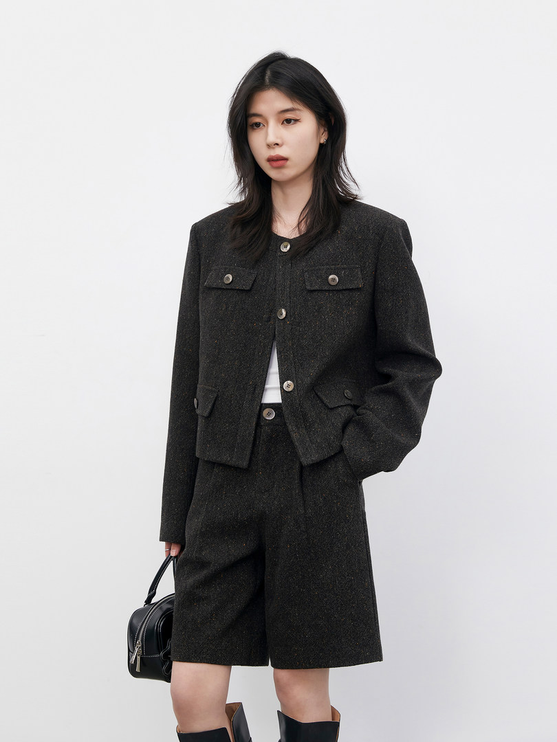 Model wearing a dark tailored jacket and matching shorts set