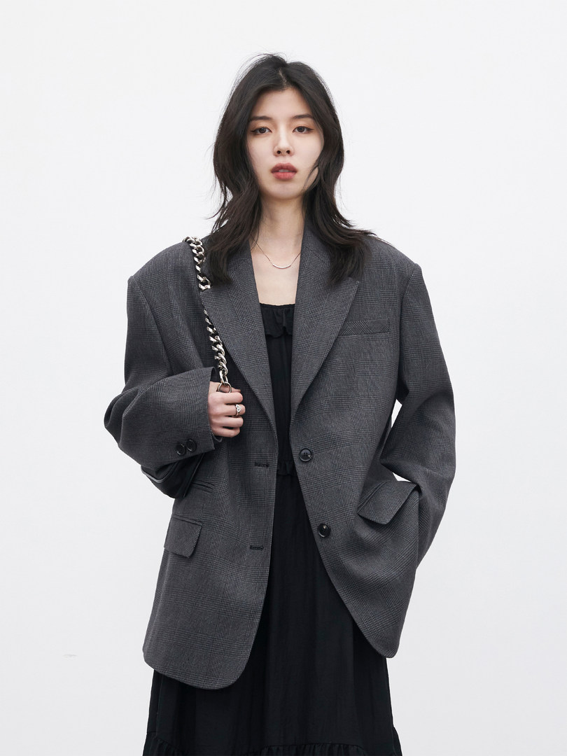 Woman wearing a dark gray oversized blazer over a black dress