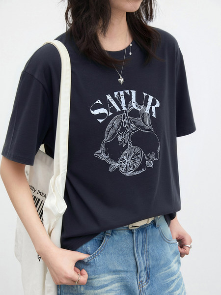 Model wearing a black graphic short-sleeve T-shirt with a white lemon print and lettering