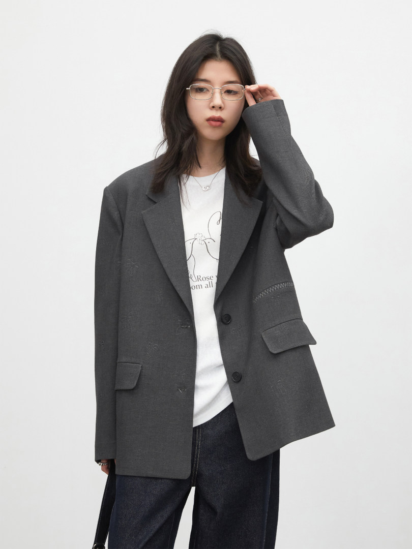 Dark gray oversized blazer worn by a model over a white shirt and jeans