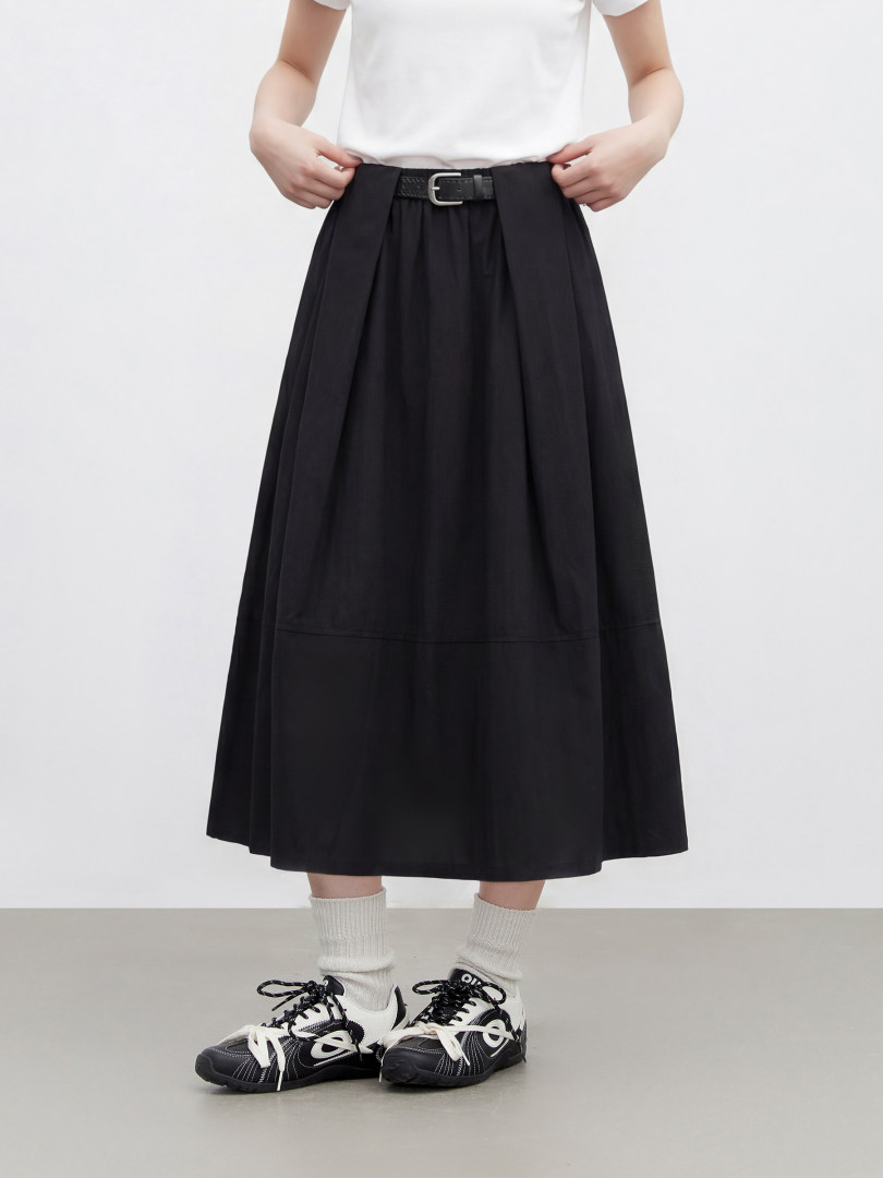 Black belted midi skirt worn by a model with sneakers