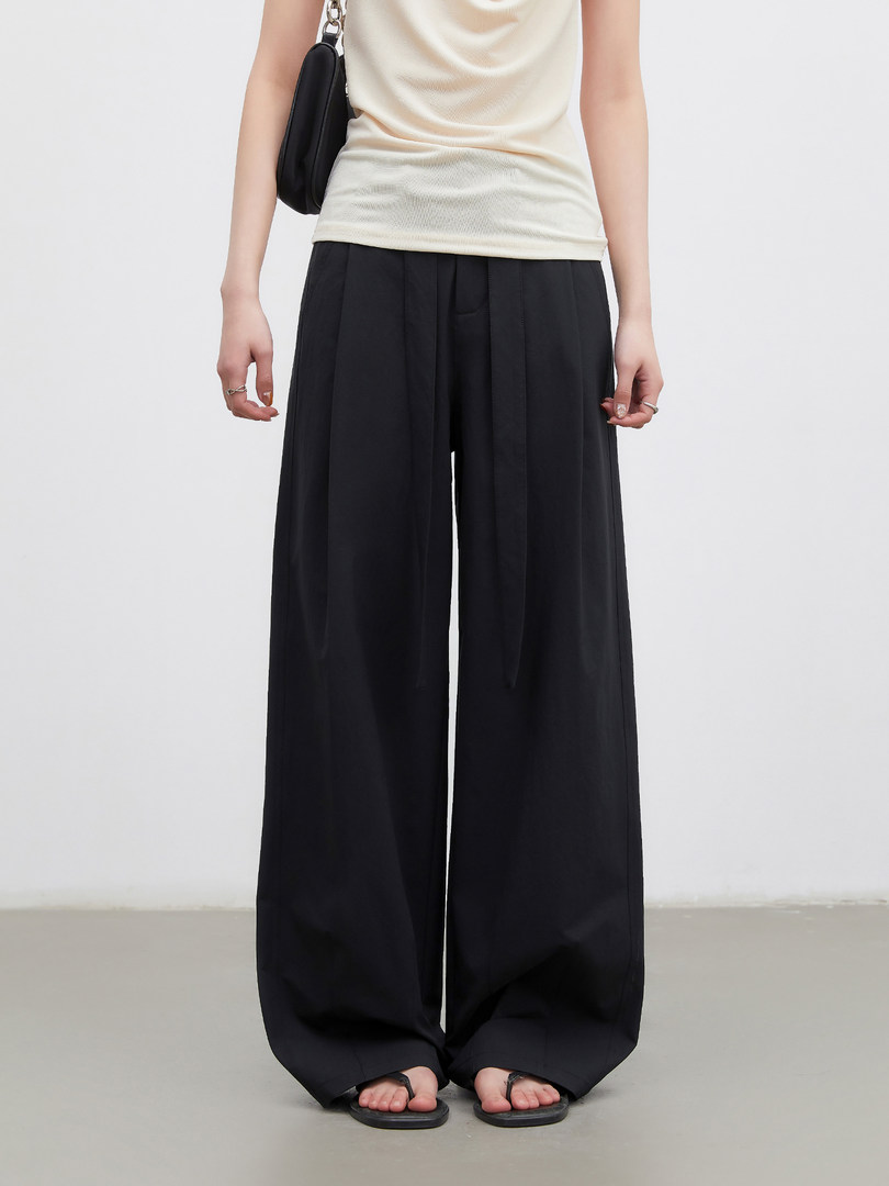 Model wearing black wide-leg pants with a sleeveless top and sandals