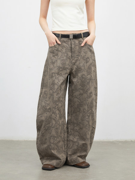 Model wearing wide-leg patterned pants with a belt