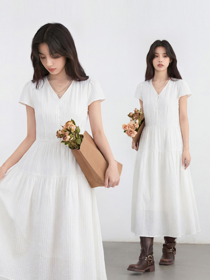 White pleated short-sleeve midi dress modeled by a woman