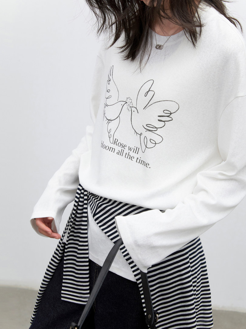 White graphic sweatshirt worn by a model with a bird print and text