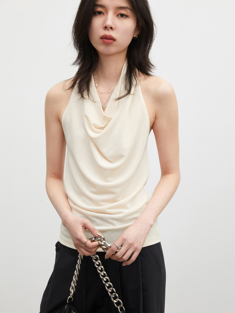 Cream draped halter top worn by a model