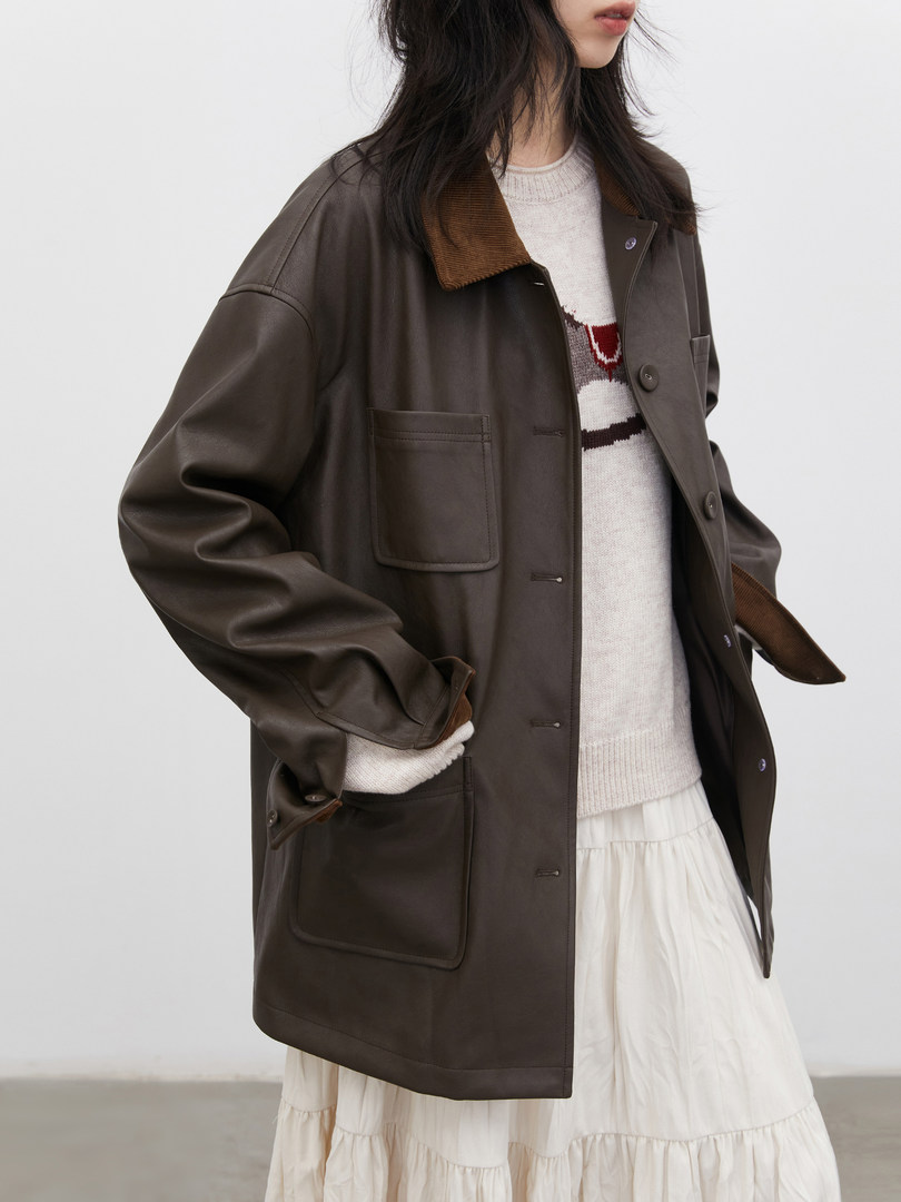 Oversized dark brown jacket worn over a light sweater and skirt